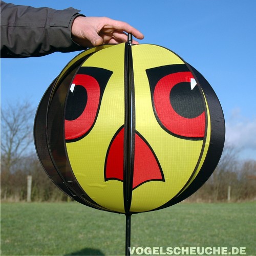 Eine Hand hält den zusammengebauten Windrotor TURBINE in Gelb zum Größenvergleich auf einem Feld.